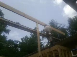 Carpenter setting a ridge beam over a new addition frame — Ice Dam Removal by Roofing Brothers in North Walpole