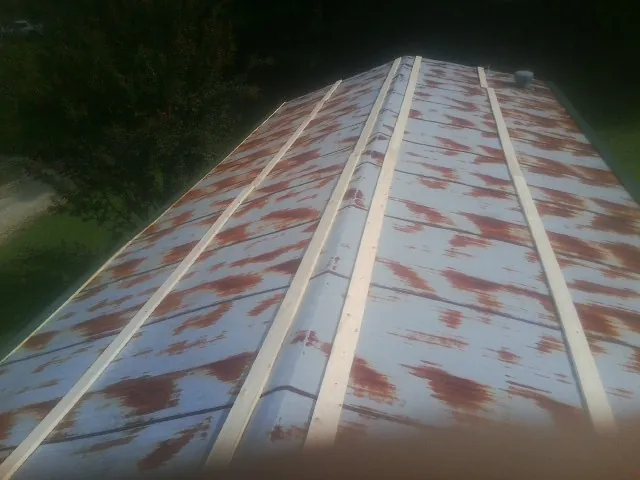 Rusted metal roof panels with new wood purlins before replacement — Storm Damage Roof Repair in North Walpole by Roofing Brothers