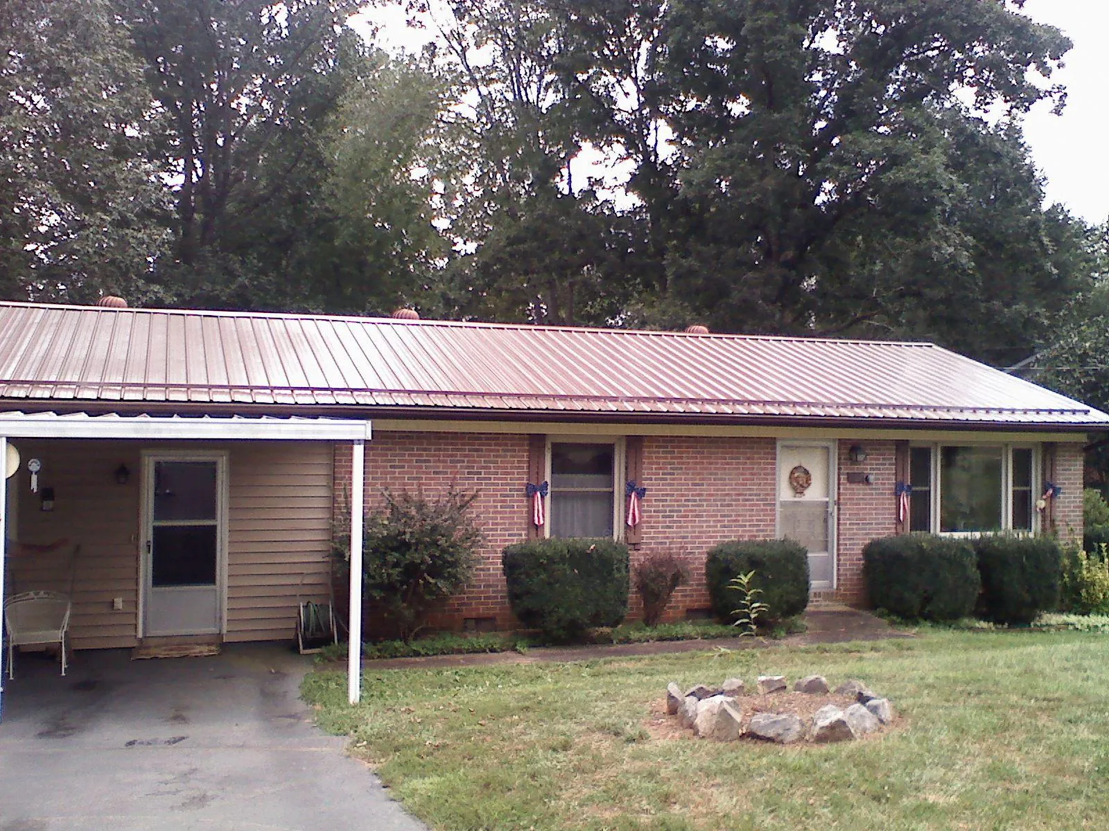 Bronze metal roof and carport on a brick ranch home — Roof Repair work by our crew in North Walpole